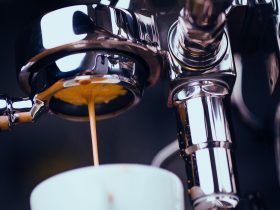 Espresso machine extracting coffee and dripping in white cup
