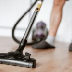 Man cleaning floor with vacuum cleaner