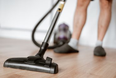 Man cleaning floor with vacuum cleaner