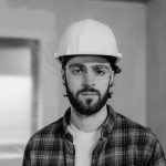 Man in white hard hat and plaid shirt