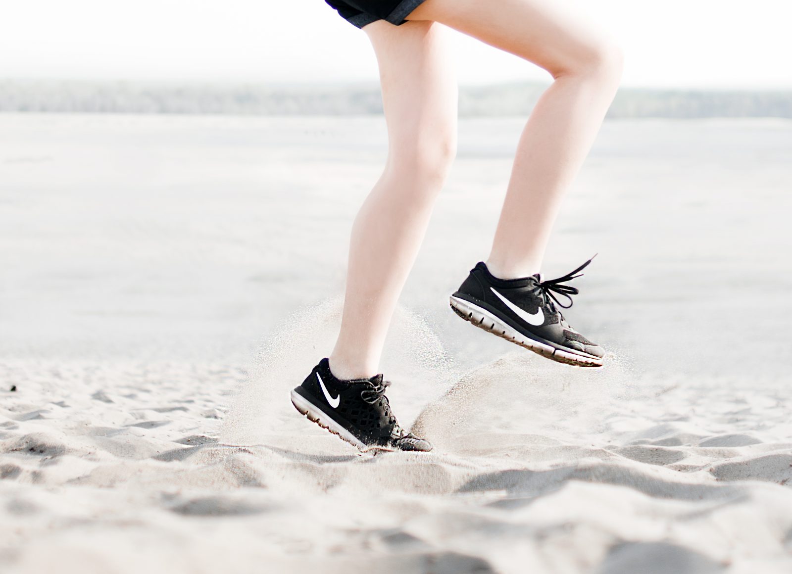 Photo of woman wearing pair of black nike running shoes