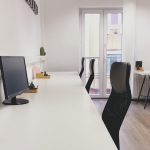 Black office rolling chair beside white wooden table