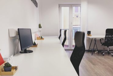 Black office rolling chair beside white wooden table
