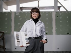 A woman posing with a catalog of color samples