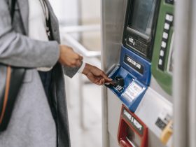 Faceless woman inserting credit card into subway ticket machine